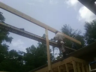 Carpenter setting a ridge beam over a new addition frame — Ice Dam Removal by Roofing Brothers in Mount Shasta