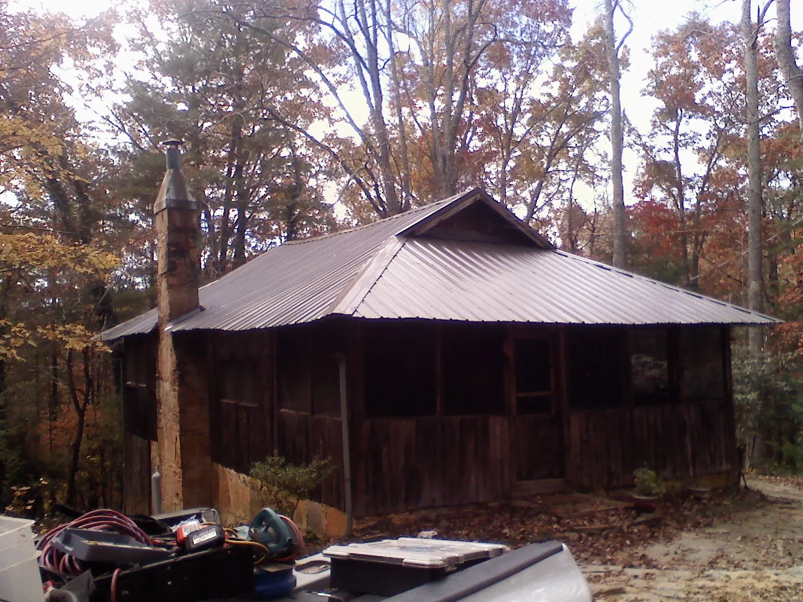 Brown metal hip roof on an old cabin with a stone chimney in Mount Shasta